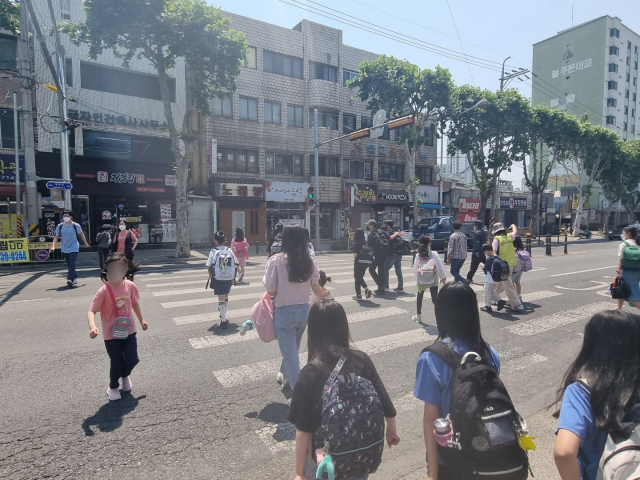18일 오후 1시쯤 찾은 대구 북구 신암초 인근 한 횡단보도. 하교하는 학생들이 보이자 운전자들도 바짝 긴장한 모습이다. 스쿨존인 이곳은 차량 속도가 시속 30km로 제한된다. 경찰은 이곳 제한 속도를 40~50km 로 완화하는 시범 운영을 올 하반기에 실시할 계획이다. 사진은 신암초 학생들이 횡단보도를 건너는 모습. 임재환 기자