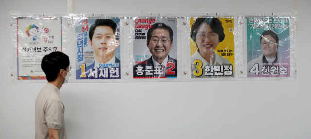 제8회 전국동시지방선거 공식 선거운동을 하루 앞둔 18일 오후 대구 서구 상중이동행정복지센터에서 선거 업무 담당자가 접수된 대구시장 후보자들의 벽보를 검점하고 있다. 김영진 기자 kyjmaeil@imaeil.com