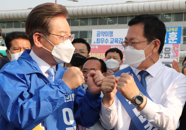 더불어민주당 이재명 총괄선대위원장이 19일 인천 계양역 광장에서 열린 더불어민주당 인천 선대위 출정식에서 박남춘 인천시장 후보와 주먹을 맞대고 있다. 연합뉴스
