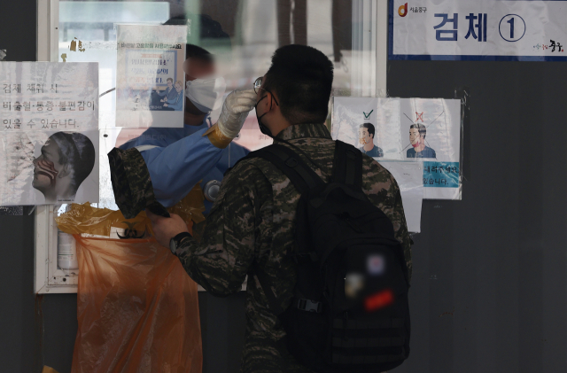 20일 오전 한 시민이 서울 중구 서울역 선별검사소에서 검체를 채취하고 있다. 연합뉴스