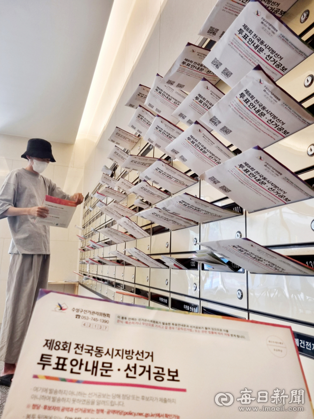22일 대구 수성구 범어동의 한 아파트에서 주민이 우편함에 배달된 제8회 전국동시지방선거 투표안내문과 선거공보물을 꺼내 확인하고 있다. 정운철 기자 woon@imaeil.com
