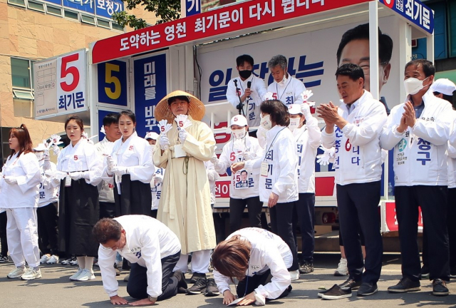 최기문 무소속 영천시장 후보 내외가 22일 영천공설시장 일원 유세에서 시민들에게 큰 절을 하고 있다. 최기문 후보 제공