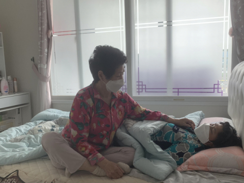 박정임(가명·76) 씨가 누워있는 아픈 딸을 바라보고 있다. 김세연 기자