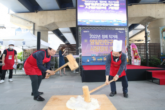 경북 포항시가 철길숲 한터마당에 우수농특산물 직거래장터를 열었다. 지난 21일 개장 행사에서 이장식(오른쪽) 부시장이 떡매치기 퍼포먼스를 선보이고 있다. 포항시 제공