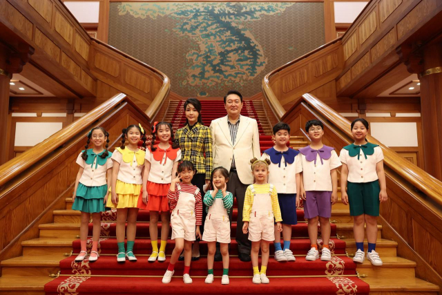 윤석열 대통령과 김건희 여사가 지난 22일 저녁 청와대 대정원 야외무대에서 열린 청와대 국민개방기념 특별기획 KBS 열린음악회가 끝난 뒤 청와대 본관에서 음악회에 출연한 합창단원들과 기념촬영을 하고 있다. 연합뉴스