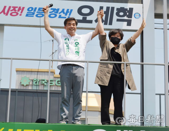 최경환 전 경제부총리 부인 장인숙씨(오른쪽)가 24일 오전 경산 하양시장에 열린 오세혁 무소속 경산시장 후보 거리유세에 참석해 오 후보와 손잡고 지지자들에게 인사를 하고 있다. 김진만 기자