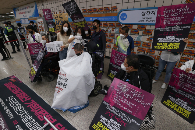 전국장애인차별철폐연대(전장연) 관계자들이 18일 오전 서울 용산구 4호선 삼각지역 승강장에서 장애인권리예산 보장을 촉구하며 삭발시위를 벌이고 있다. 연합뉴스