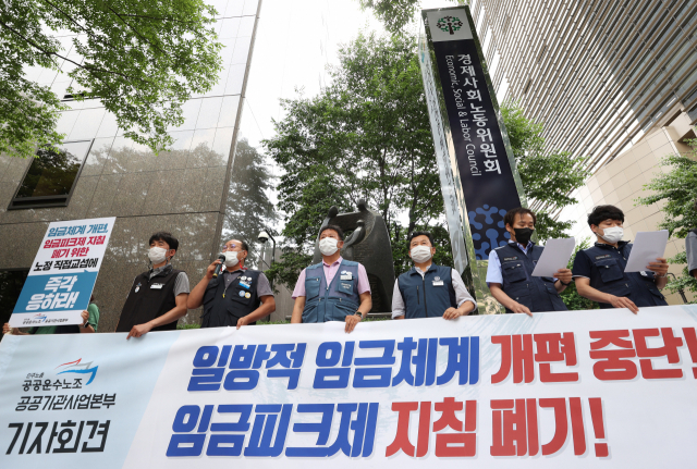 지난해 6월 제2기 경제사회노동위원회(경노사위) 공공기관위원회가 출범하는 경노사위 사무실 앞에서 공공운수노조 주최로 열린 기자회견에서 참가자들이 공공기관의 일방적 임금체계 개편 중단과 임금피크제 지침 폐기를 촉구하고 있다. 연합뉴스