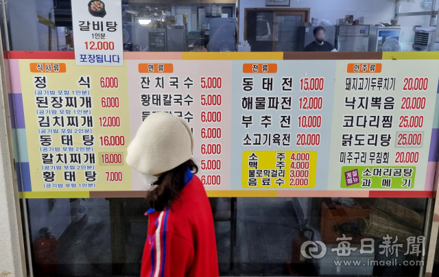 대구 수성구의 한 식당에 붙은 메뉴판 앞으로 손님이 지나가고 있다. 중구 동성로의 한 식당 주인은 
