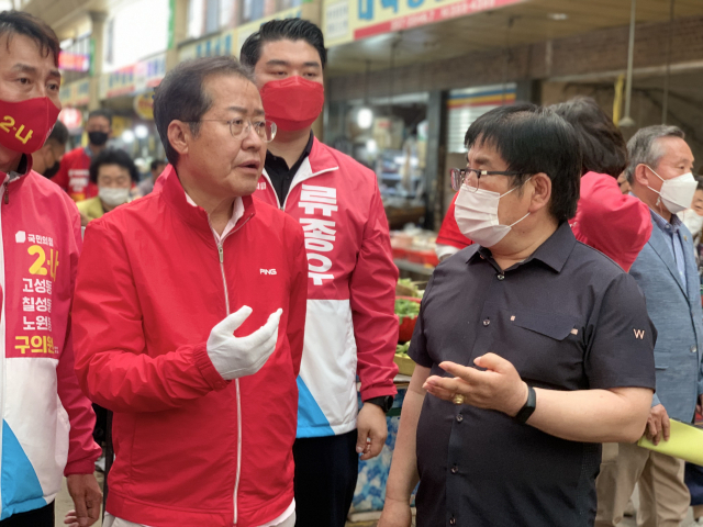 홍준표 국민의힘 대구시장 후보는 25일 오후 대구 북구 팔달시장을 방문, 시장 상인을 만나 현장의 애로를 듣는 한편 전통시장 현황을 살폈다. 사진은 홍 후보가 시장 상인회 관계자로부터 팔달시장 관련 설명을 듣는 모습. 2022.5.26. 홍준표 기자