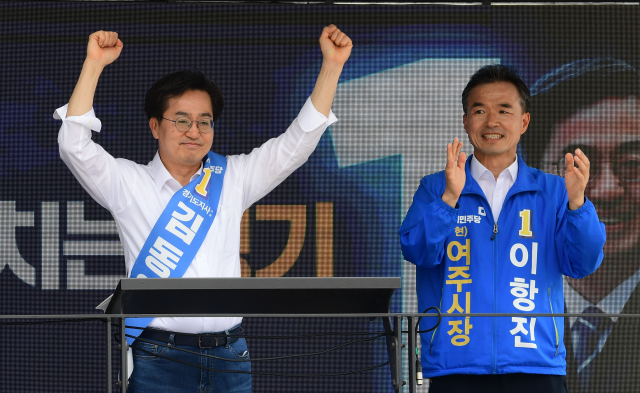 더불어민주당 김동연 경기도지사 후보가 25일 경기도 여주 한글시장에서 손을 들어 지지자들에게 인사하고 있다. 연합뉴스