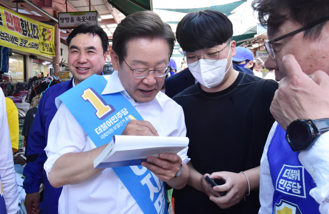 더불어민주당 이재명 총괄선대위원장이 31일 인천시 남동구 모래내 시장을 방문해 한 시민에게 사인을 해주고 있다. 연합뉴스