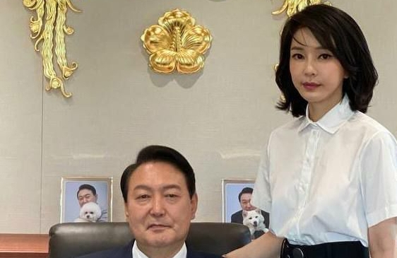 윤석열 대통령과 김건희 여사가 대통령실 집무실에서 대통령 표장을 배경으로 촬영한 사진이 30일 공개됐다. 윤 대통령 뒤로는 반려견 토리, 써니와 함께 찍은 윤 대통령의 사진이 놓여 있다. 연합뉴스