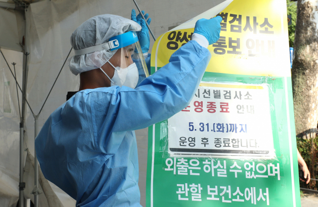 5월 31일 오후 서울 종로구 탑골공원에 마련된 코로나 19 선별검사소에서 관계자가 안내문을 철거하고 있다. 정부는 코로나19 감소세에 따라 내일부터 임시선별검사소와 생활치료센터의 운영을 중단한다. 연합뉴스
