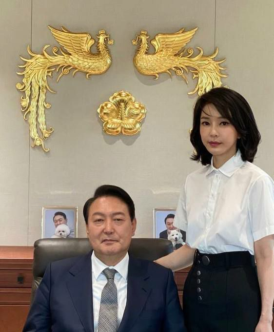 윤석열 대통령과 김건희 여사가 대통령실 집무실에서 대통령 표장을 배경으로 촬영한 사진이 30일 공개됐다. 윤 대통령 뒤로는 반려견 토리, 써니와 함께 찍은 윤 대통령의 사진이 놓여 있다. 연합뉴스