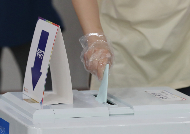 제8회 전국동시지방선거일인 1일 오전 울산시 남구 신정4동 제5투표소가 마련된 동백초등학교 체육관에서 한 유권자가 비닐장갑을 낀 채 투표하고 있다. 연합뉴스