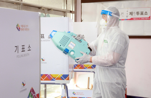 제8회 전국동시지방선거를 하루 앞둔 31일 오후 대구 남구 대구중학교 급식실에 설치된 투표소에서 방역작업이 진행되고 있다. 연합뉴스