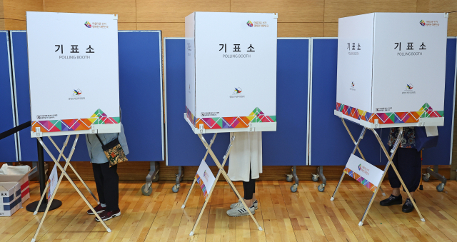 제8회 전국동시지방선거일인 1일 오전 서울 서대문구 홍은2동 주민센터에 마련된 투표소를 찾은 유권자들이 투표하고 있다. 연합뉴스