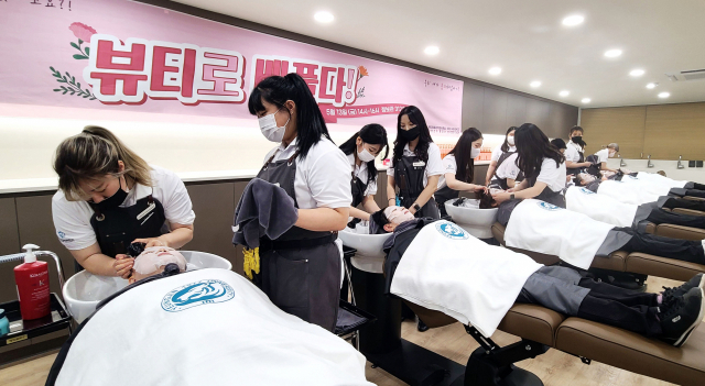 영진전문대 뷰티융합과 교수와 학생들은 미화원 20여 명을 초청해 두피 관리를 위한 스케일링, 모발 클리닉, 힐링 마사지, 헤드스파 샴푸잉 등을 선보였다. 영진전문대 제공
