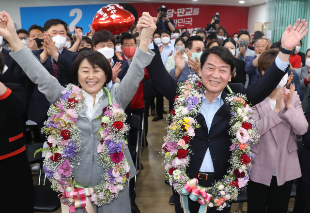 경기 성남 분당갑 국회의원 보궐선거에 출마한 국민의힘 안철수 후보가 1일 오후 당선이 확실시 되자 분당 선거사무소에서 아내 김미경씨와 함께 꽃을 받아들고 세리머니를 하고 있다. 연합뉴스