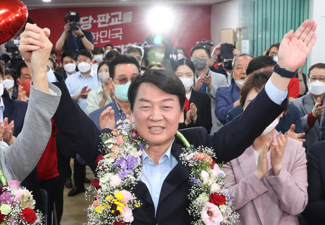 경기 성남 분당갑 국회의원 보궐선거에 출마한 국민의힘 안철수 후보가 1일 오후 당선이 확실시 되자 분당 선거사무소에서 꽃을 받아들고 세리머니를 하고 있다. 연합뉴스