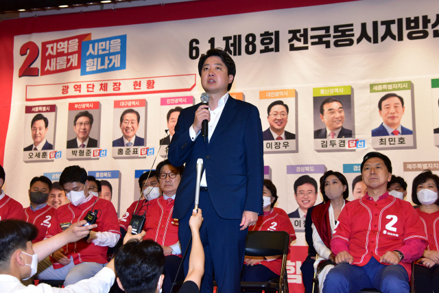 국민의힘 이준석 대표가 1일 오후 국회 도서관 대강당에 마련된 지방선거 개표상황실에서 당선이 유력시되는 단체장 후보 사진 밑에 스티커를 붙인 뒤 소감을 밝히고 있다. 연합뉴스