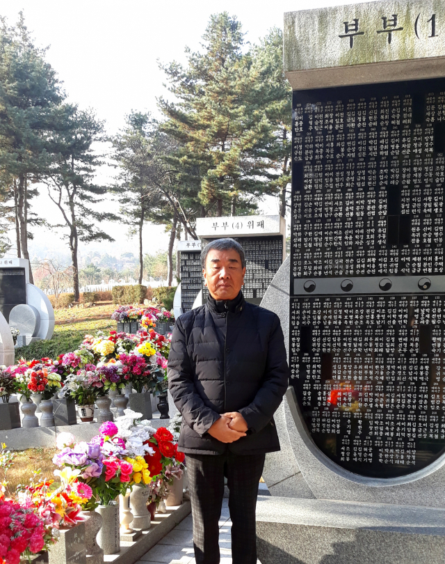 아버지와 어머니가 모셔져 있는 서울 국립현충원의 묘비에 선 아들 손상웅 씨. 가족 제공.