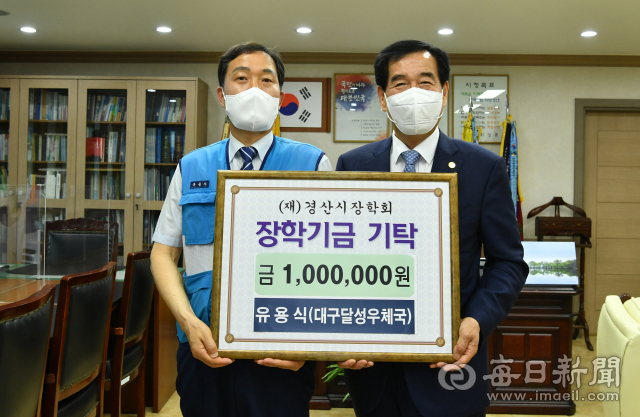 유용식(왼쪽) 대구 달성우체국 집배원이 2일 경산시장학회에 장학금 100만원을 기탁했다. 경산시 제공