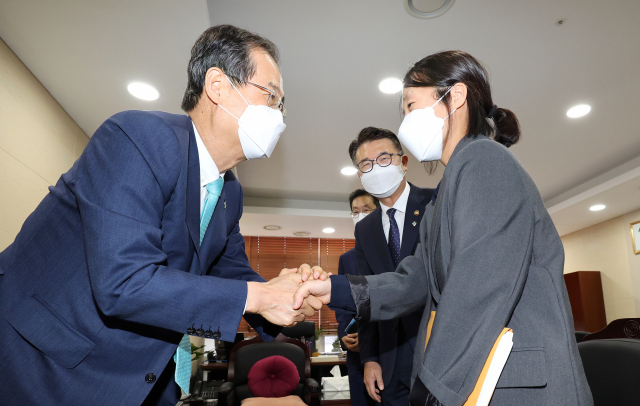 한덕수 국무총리(왼쪽)가 9일 세종시 정부세종청사 교육부를 방문해 정상은 인재양성정책과장과 인사하며 격려하고 있다. 연합뉴스
