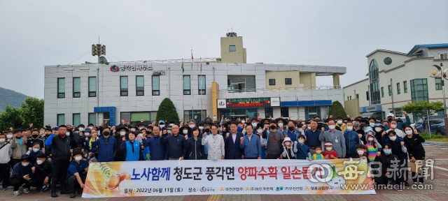 경북 청도군 풍각면과 1사 촌 자매결연 한 아진산업㈜ 임직원들이 11일 농촌 일손돕기에 나가기 전 풍각면사무소에서 기념사진을 찍고 있다. 아진산업 제공