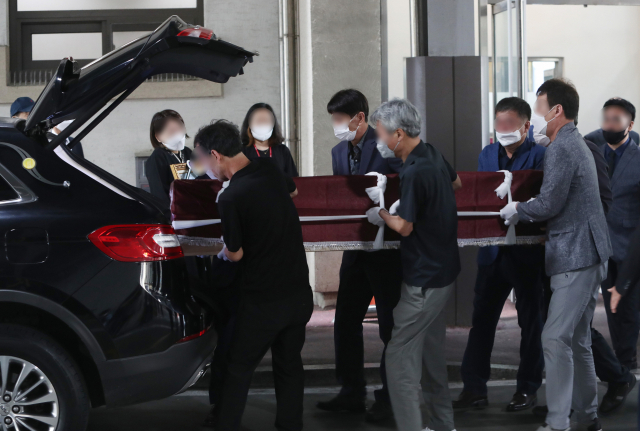 12일 대구 중구 경북대병원 장례식장에서 열린 변호사 사무실 방화사건 희생자들의 발인식에서 유족과 지인들이 희생자들의 관을 운구하고 있다. 연합뉴스