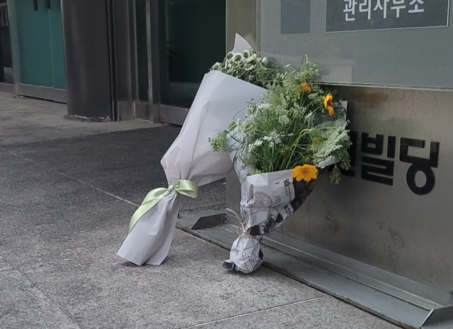 법률사무소 방화 참사 현장 건물 앞에 추모객들이 두고 간 국화 꽃다발이 놓여 있다. 매일신문DB