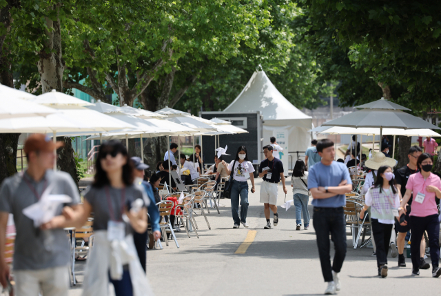 휴일을 맞아 12일 오후 서울 용산공원 시범개방 행사를 찾은 시민들이 용산공원 가로수길을 오가고 있다. 연합뉴스