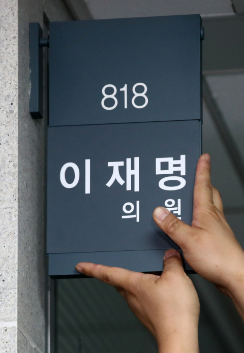 더불어민주당 이재명 의원이 7일 오전 국회 의원회관에 첫출근하기 전 국회 직원이 818호에 명패를 걸고 있다. 연합뉴스