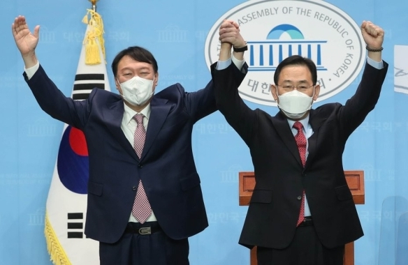 2021년 10월 17일 국민의힘 윤석열 대선 경선 후보(왼쪽)와 선거대책위원장으로 합류한 주호영 의원이 서울 여의도 국회 소통관에서 공동 기자회견을 가진 후 손을 맞잡아 들어 인사하고 있다. 연합뉴스