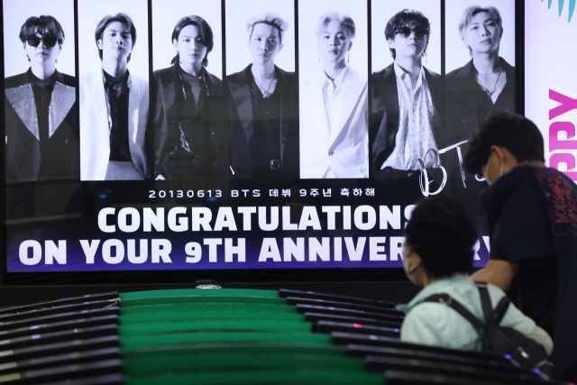 그룹 방탄소년단(BTS)이 팀 활동 잠정 중단 선언한 15일 오후 서울 지하철 2호선 강남역에 데뷔 9주년 축하 영상이 상영되고 있다. 연합뉴스