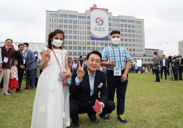 윤석열 대통령이 19일 오후 용산 대통령실 청사 앞 잔디광장에서 열린 대통령실 이전 기념 주민 초대 행사에서 아프가니스탄 특별기여자 가족의 자녀들과 기념촬영을 하고 있다. 연합뉴스