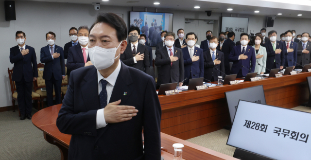 윤석열 대통령이 21일 서울 용산 대통령실 청사에서 열린 국무회의에서 국기에 경례를 하고 있다. 연합뉴스