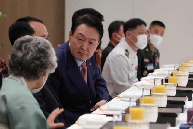 윤석열 대통령이 9일 오전 서울 용산 대통령실 청사에서 열린 '호국영웅 초청 소통식탁' 행사에 앞서 천안함 희생자인 고(故) 민평기 상사의 모친 윤청자 여사의 발언을 경청하고 있다. 오찬에는 천안함 생존 장병과 희생자 유족, 천안함 실종자 구조 과정에서 순직한 고 한주호 준위 유족, 연평해전과 북한의 목함지뢰 도발 희생자 유족 등 20명이 참석했다. 연합뉴스