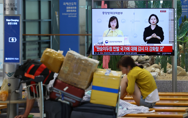 원숭이두창 국내 의심 환자 1명이 방역 당국의 유전자증폭(PCR) 검사에서 양성 판정을 받은 것으로 알려진 22일 오후 인천국제공항 제1여객터미널 입국장에 설치된 TV에 질병관리청의 브리핑이 생중계되고 있다. 연합뉴스