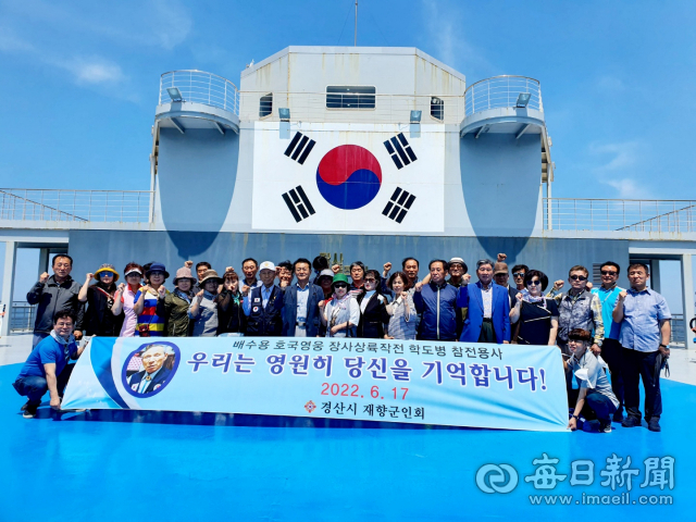 경산시재향군인회가 지난 17일 장사상륙작전 전승기념관 견학을 하면서 배수용(앞줄 왼쪽 8번째) 호국영웅을 우리는 영원히 기억하겠다는 현수막을 내걸고 기념촬영을 했다. 경산시재향군인회 제공