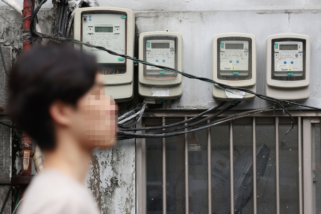 서울 시내의 전기계량기 앞을 한 시민이 지나가고 있다. 연합뉴스