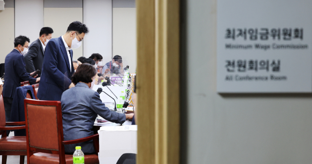 내년도 최저임금 심의에 참여 중인 노동계와 경영계가 최저임금 최초 요구안의 수정안을 각각 제출한 28일 오후 세종시 정부세종청사 최저임금위원회 회의실에서 열린 제7차 전원회의가 잠시 휴정한 뒤 다시 시작되자 사용자위원과 근로자위원들이 착석하고 있다. 연합뉴스