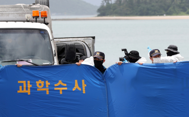 29일 오전 전남 완도군 신지면 송곡선착장 인근 방파제에서 경찰이 10ｍ 바닷속에 잠겨있는 조유나(10)양 가족의 차량을 인양한 뒤 차량 내부를 촬영하고 있다. 경찰은 실종된 조양의 가족과 차량을 찾기 위해 수중 수색하다 전날 가두리양식장 아래에 잠겨있는 차량을 발견했다. 연합뉴스