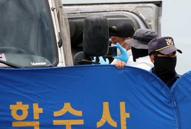 29일 오전 전남 완도군 신지면 송곡선착장 인근 방파제에서 경찰이 10ｍ 바닷속에 잠겨있는 조유나(10)양 가족의 차량을 인양한 뒤 차량 내부를 촬영하고 있다. 경찰은 실종된 조양의 가족과 차량을 찾기 위해 수중 수색하다 전날 가두리양식장 아래에 잠겨있는 차량을 발견했다. 연합뉴스