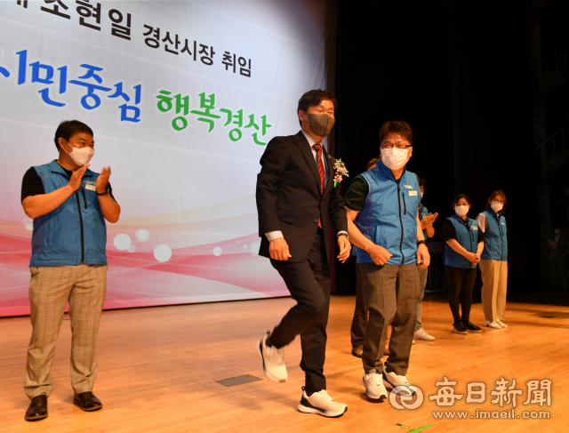 조현일 경산시장 취임식에서 조 시장이 이상현 경산시 공무원노동조합장으로부터 받은 희색운동화를 신고 함께 뛰는 모습을 연출했다. 경산시 제공