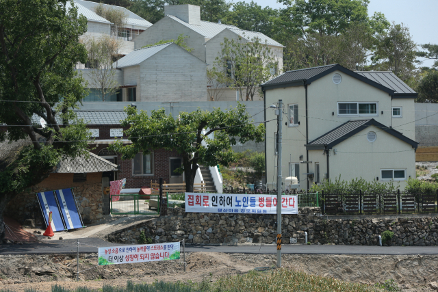 지난해 5월 25일 경남 양산시 하북면 지산리 평산마을 문재인 전 대통령 사저 앞에 문 전 대통령 반대단체 집회, 1인 시위에 항의하는 마을주민 현수막이 내걸려 있다. 연합뉴스