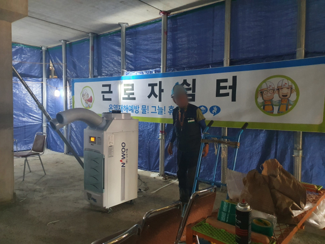 대구 달서구의 한 건설 현장에 설치된 근로자 쉼터. 근로자 정유봉(65) 씨가 냉방기 앞으로 가고 있다. 배주현 기자