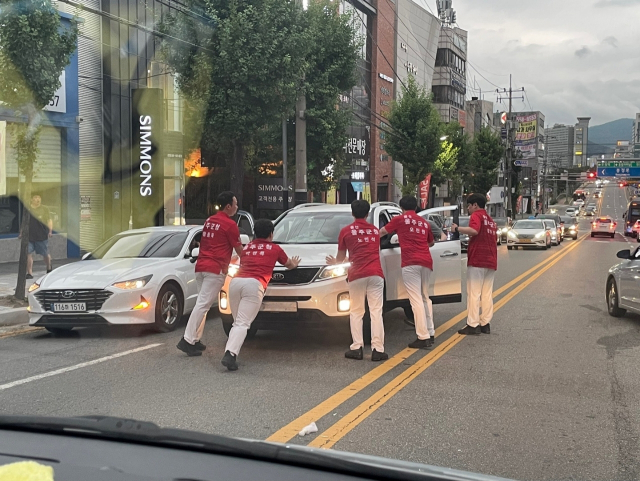 지난 7일 울주군청 볼링팀 선수들이 숙소로 귀가 중 천안 성정동 한 도로에서 음주운전 의심 차량을 목격하고 차량을 멈춰 세우고 있다. 사진=울주군청제공