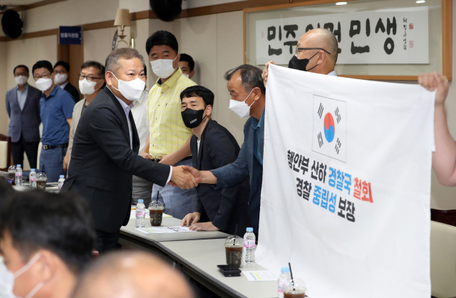 행정안전부 경찰국 신설 등으로 일선 경찰관들의 반발이 거센 가운데 이상민 행정안전부 장관이 12일 오후 대구 경찰청을 찾아 일선 경찰관들과 간담회를 하기에 앞서 악수를 하고 있다. 일부 참석자들이 경찰국 신설 반대를 적은 플래카드를 들고 있다. 연합뉴스